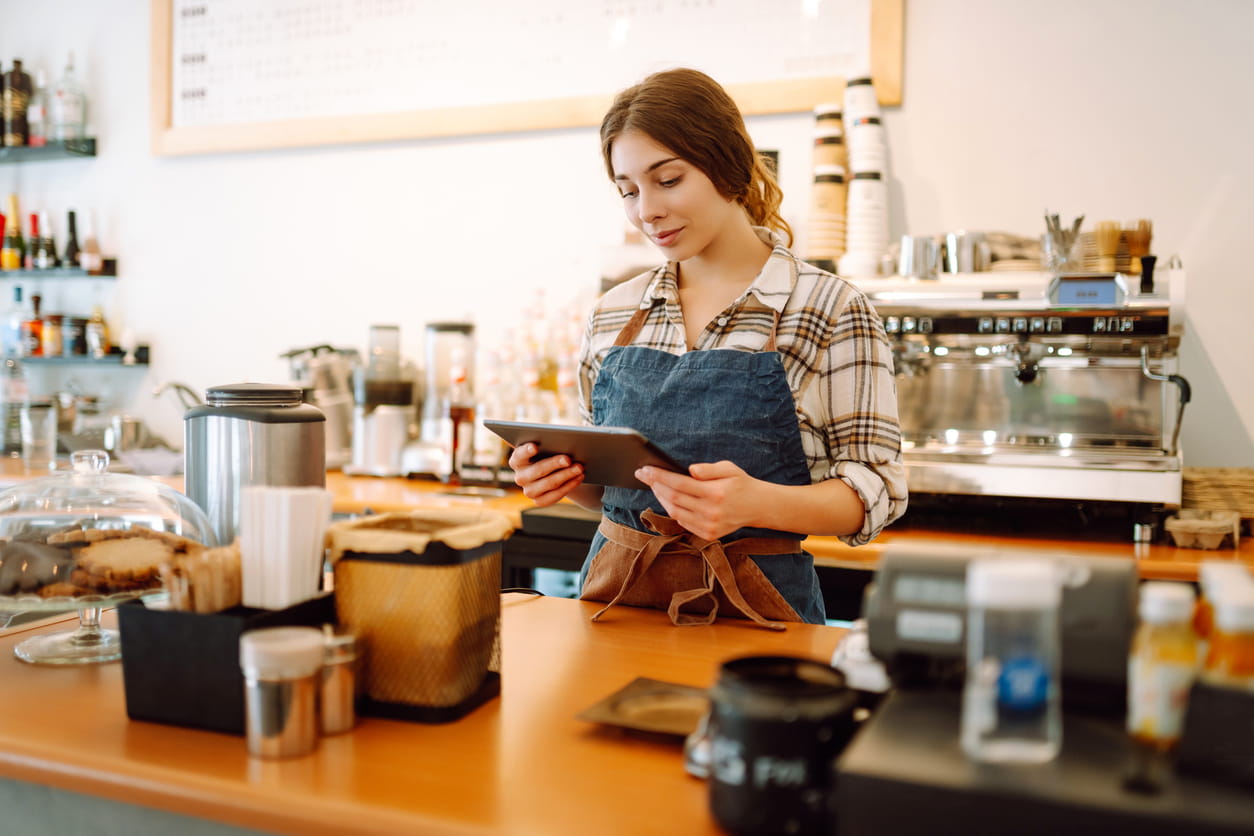 Camarera de cafeteria tomando comanda desde la barra